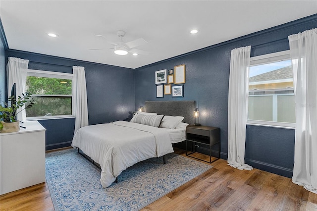 bedroom with a textured wall, wood finished floors, baseboards, ceiling fan, and recessed lighting