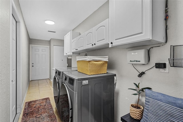 washroom featuring baseboards, cabinet space, washing machine and dryer, and visible vents