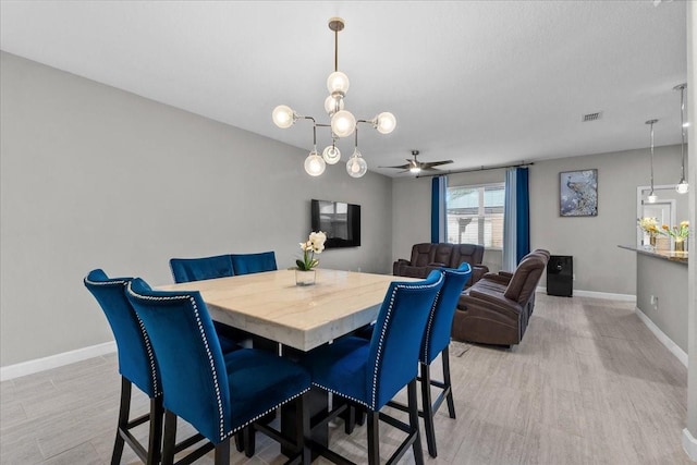 9009 Savannah Julip Ln, Orlando, FL 32832 - dining area with baseboards, light wood-style floors, a ceiling fan, and a chandelier