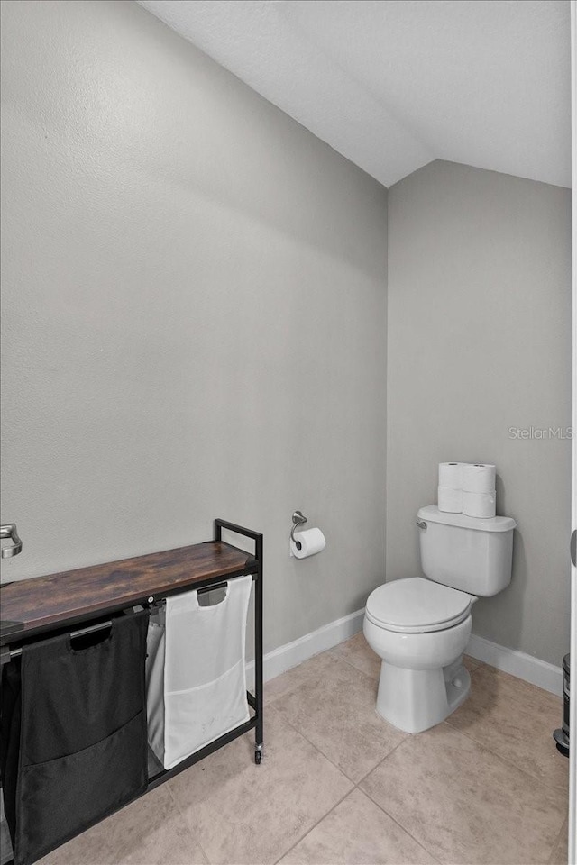 9009 Savannah Julip Ln, Orlando, FL 32832 - bathroom with toilet, vaulted ceiling, baseboards, and tile patterned floors
