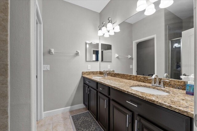 9009 Savannah Julip Ln, Orlando, FL 32832 - bathroom featuring a stall shower, tile patterned flooring, double vanity, baseboards, and a chandelier