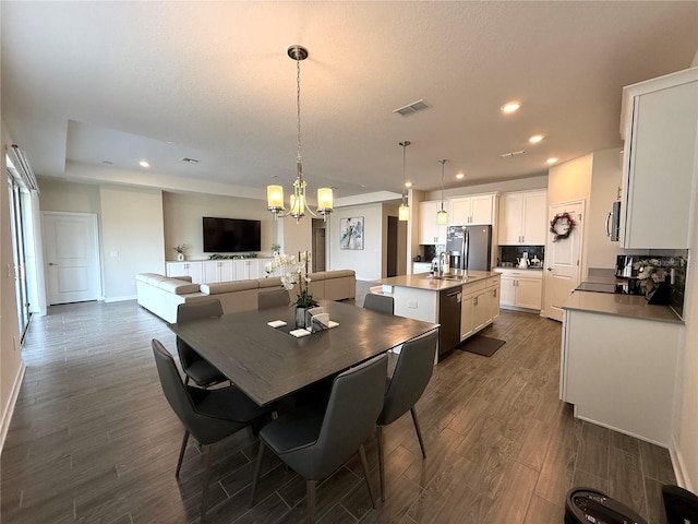 dining area with recessed lighting, visible vents, an inviting chandelier, and dark wood-type flooring