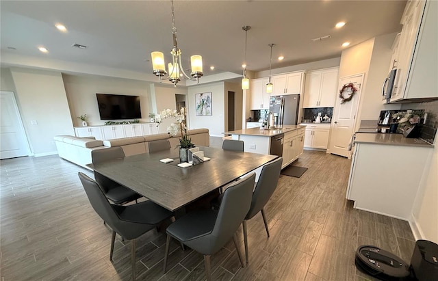 dining space featuring recessed lighting, dark wood-style flooring, baseboards, and a notable chandelier