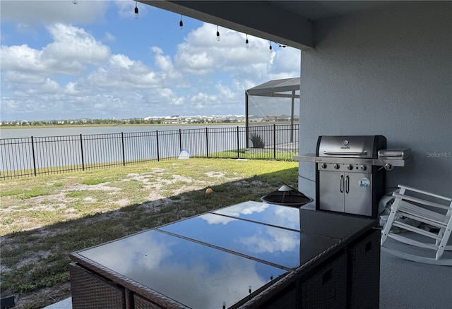 view of patio with a fenced backyard, a water view, and grilling area