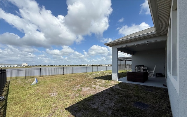 view of yard with a water view, a patio area, and a fenced backyard