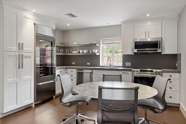 1640 E Adams Dr, Maitland, FL 32751 - kitchen featuring appliances with stainless steel finishes, a sink, dark wood-style flooring, white cabinets, and recessed lighting