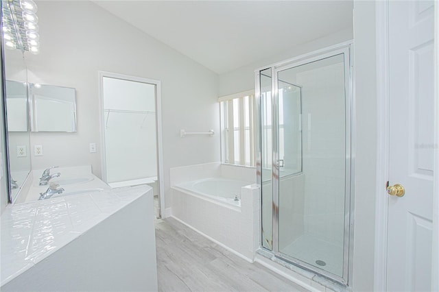 13434 Mallard Cove Blvd, Orlando, FL 32837 - full bathroom featuring vaulted ceiling, wood finished floors, a garden tub, a stall shower, and double vanity