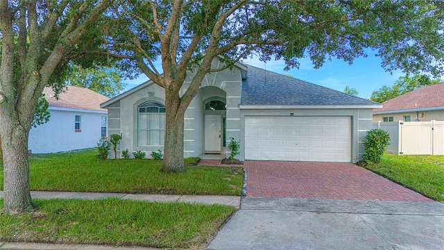 13434 Mallard Cove Blvd, Orlando, FL 32837 - ranch-style home featuring decorative driveway, stucco siding, roof with shingles, and an attached garage