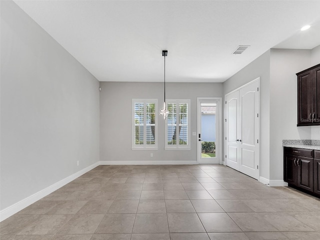 unfurnished dining area featuring light tile patterned floors, baseboards, and visible vents