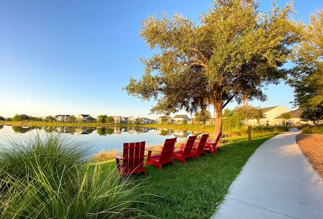view of home's community featuring a water view, a yard, and a residential view