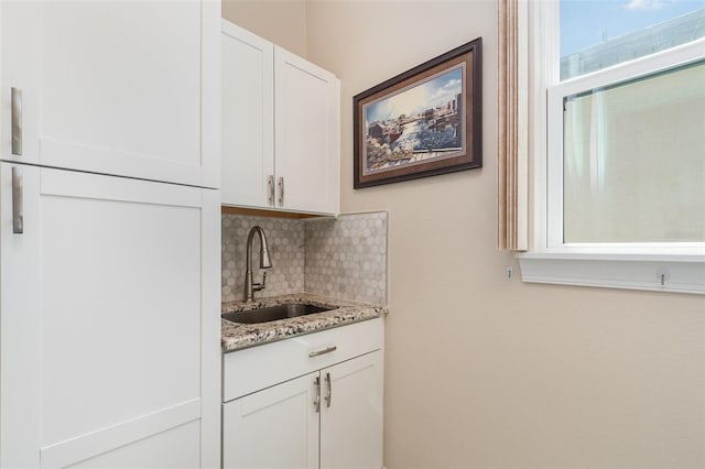 bar featuring a sink and tasteful backsplash