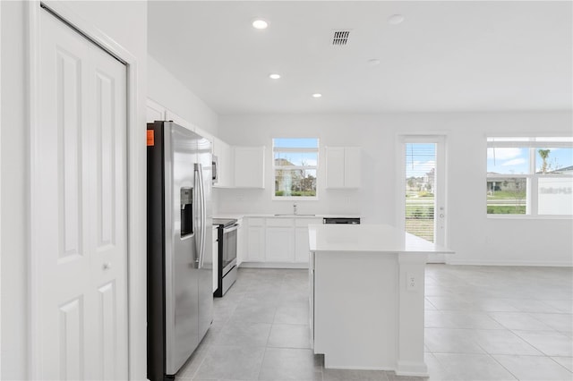 kitchen with visible vents, a sink, light tile patterned flooring, and stainless steel appliances