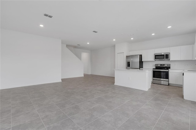 kitchen featuring light countertops, stainless steel appliances, open floor plan, recessed lighting, and visible vents