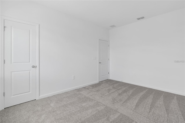 carpeted empty room with baseboards and visible vents
