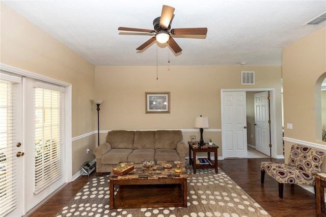 living area with arched walkways, ceiling fan, wood finished floors, and visible vents
