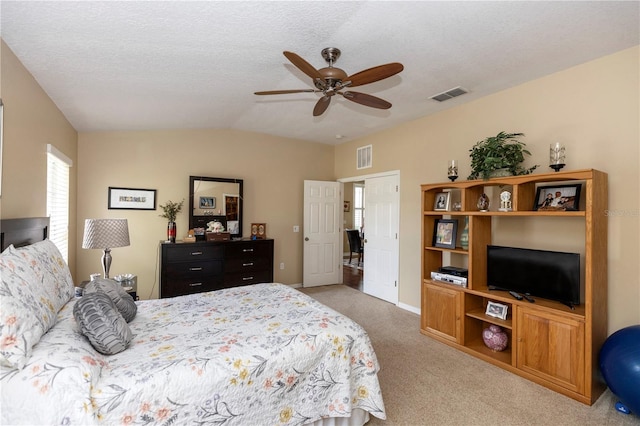 carpeted bedroom with a ceiling fan, baseboards, visible vents, and vaulted ceiling