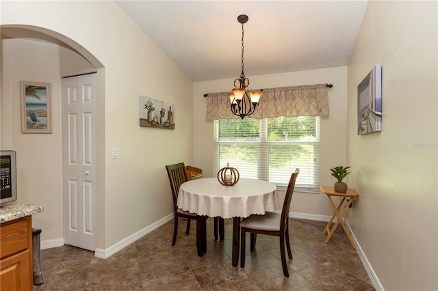 dining space featuring an inviting chandelier, arched walkways, and baseboards