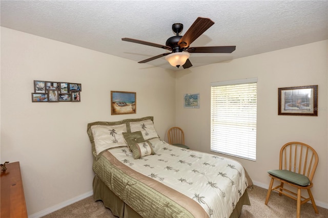 bedroom featuring a textured ceiling, baseboards, light carpet, and ceiling fan