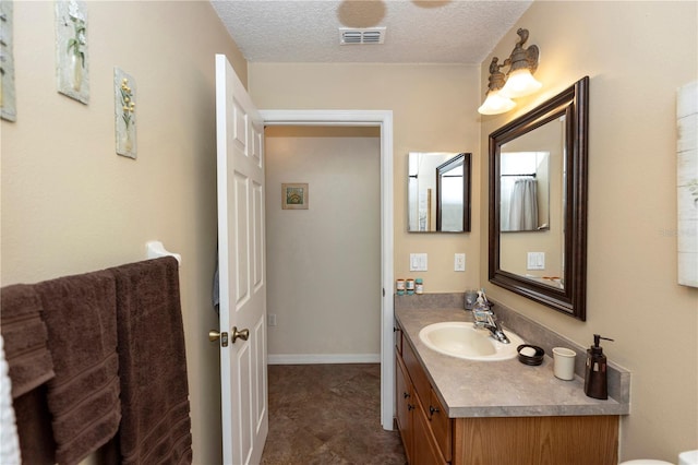 bathroom featuring vanity, a textured ceiling, and visible vents