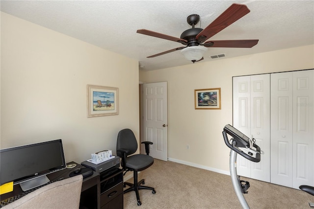 office featuring a textured ceiling, a ceiling fan, light colored carpet, and visible vents