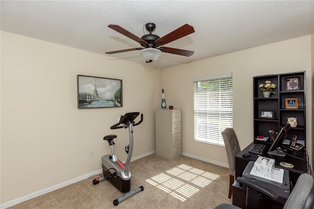 office space with baseboards, ceiling fan, carpet flooring, and a textured ceiling
