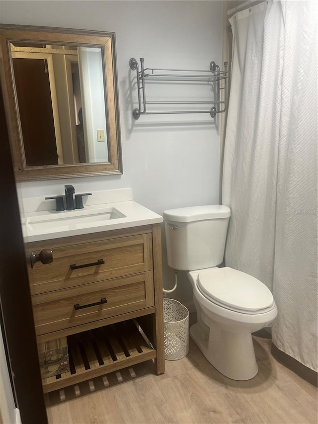 full bathroom featuring toilet, wood finished floors, and vanity