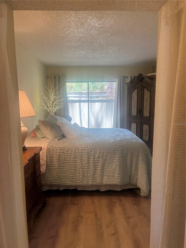 bedroom featuring a textured ceiling and wood finished floors