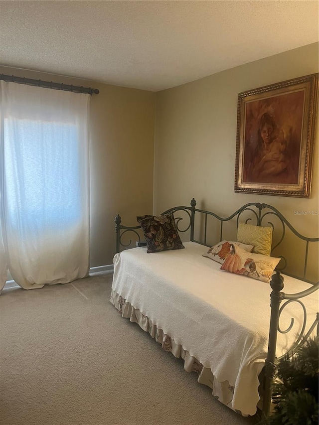 bedroom with a textured ceiling and light colored carpet