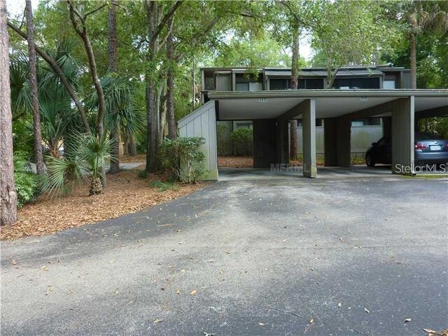 view of parking / parking lot featuring driveway and a carport