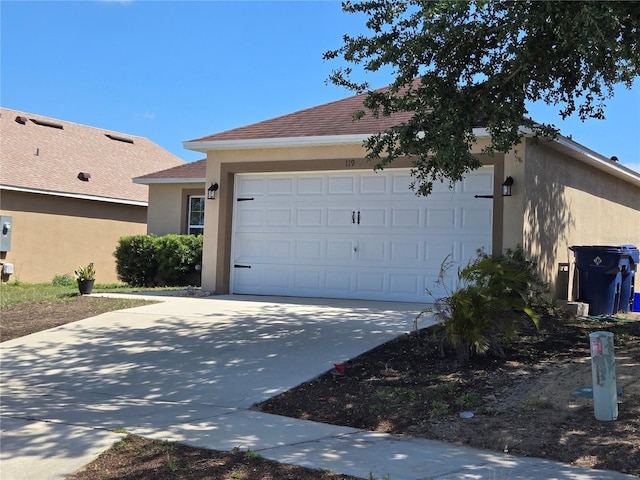 119 Stewart Lake Loop, Groveland, FL 34736 - view of home's exterior featuring stucco siding, concrete driveway, a garage, and roof with shingles