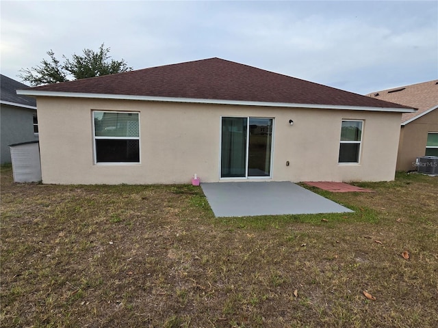 119 Stewart Lake Loop, Groveland, FL 34736 - rear view of property featuring a patio, a lawn, stucco siding, and a shingled roof