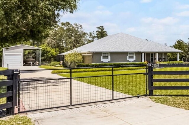 view of gate with a yard, fence, and an outbuilding