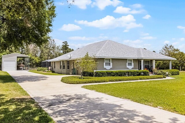 single story home featuring a shingled roof, stucco siding, a front yard, and concrete driveway