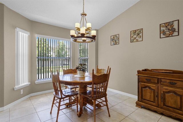dining room with baseboards, lofted ceiling, light tile patterned floors, and a notable chandelier