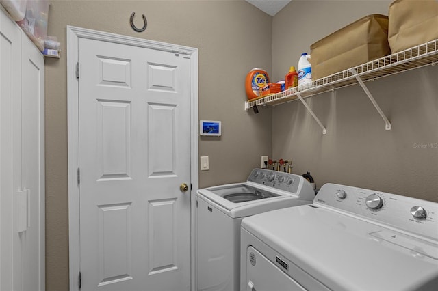 clothes washing area featuring laundry area and washing machine and clothes dryer