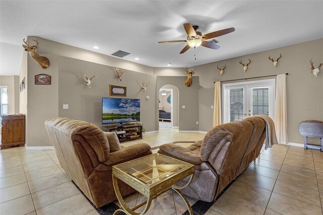 living room featuring a ceiling fan, visible vents, arched walkways, recessed lighting, and light tile patterned flooring