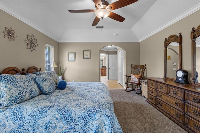bedroom featuring a ceiling fan, crown molding, arched walkways, carpet floors, and a tray ceiling