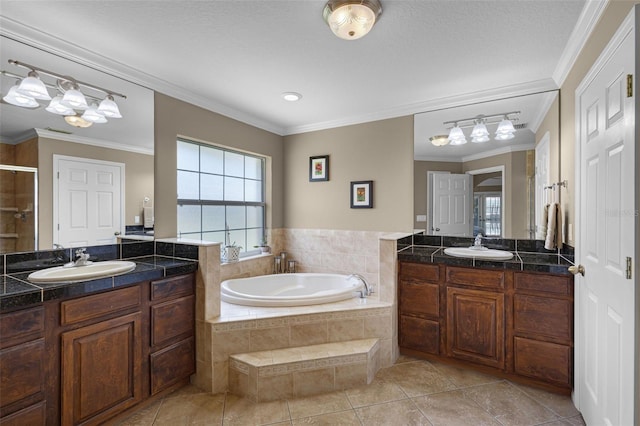 full bath featuring crown molding, a sink, a garden tub, and a stall shower