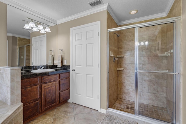full bathroom featuring crown molding, vanity, tile patterned floors, visible vents, and a stall shower