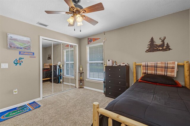 carpeted bedroom featuring baseboards, visible vents, ceiling fan, and a closet