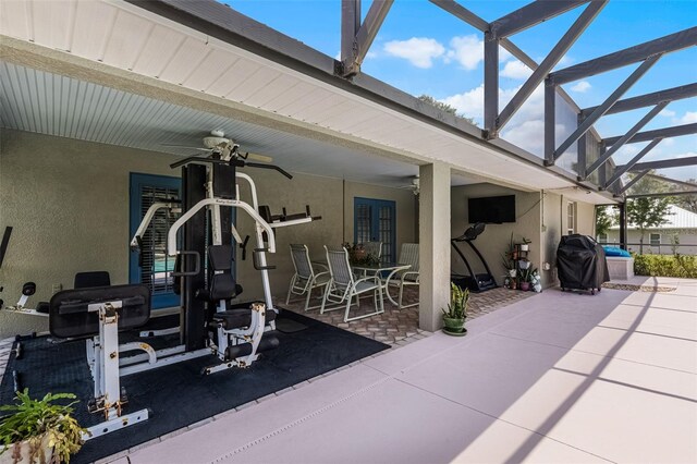 view of patio featuring a lanai, outdoor dining space, ceiling fan, and area for grilling