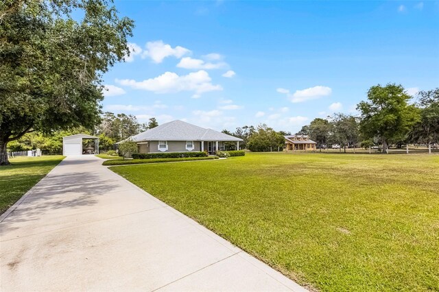 view of front of home with driveway, a carport, and a front lawn