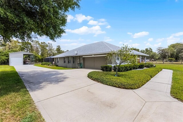 single story home with concrete driveway, an attached garage, a detached carport, and a front lawn