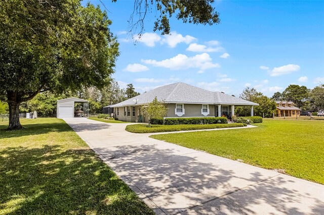 view of front of house with concrete driveway, stucco siding, a carport, and a front lawn