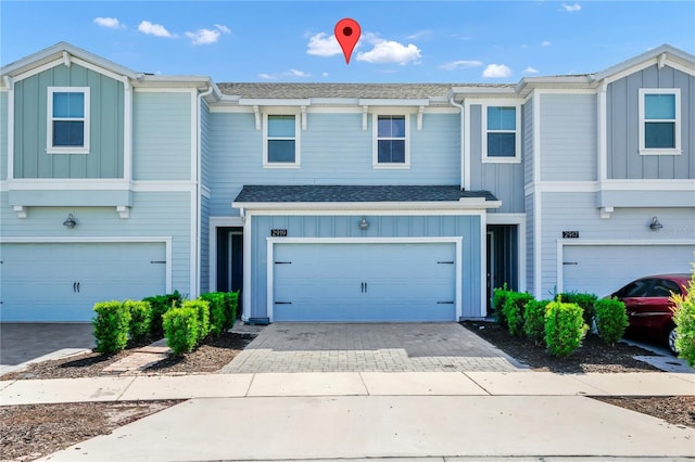2919 Verse St, Kissimmee, FL 34746 - view of property featuring a garage, board and batten siding, and decorative driveway