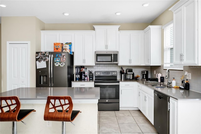 2919 Verse St, Kissimmee, FL 34746 - kitchen featuring a sink, appliances with stainless steel finishes, decorative backsplash, and white cabinets