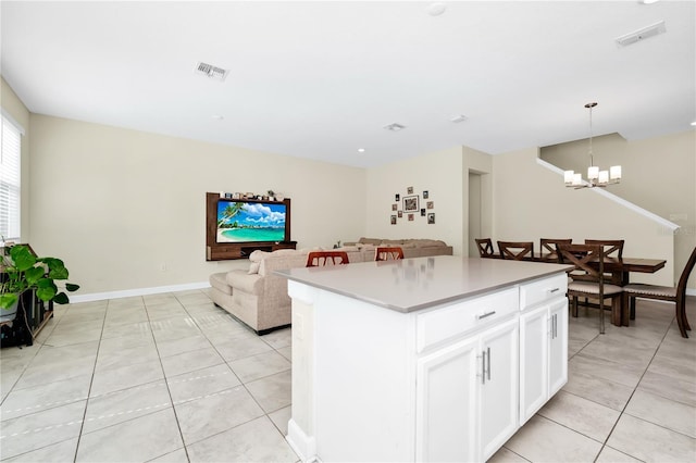2919 Verse St, Kissimmee, FL 34746 - kitchen featuring visible vents, a kitchen island, white cabinets, a chandelier, and light tile patterned floors