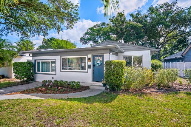 ranch-style house featuring fence and a front yard