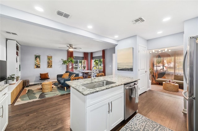 kitchen with stainless steel appliances, open floor plan, visible vents, and a sink