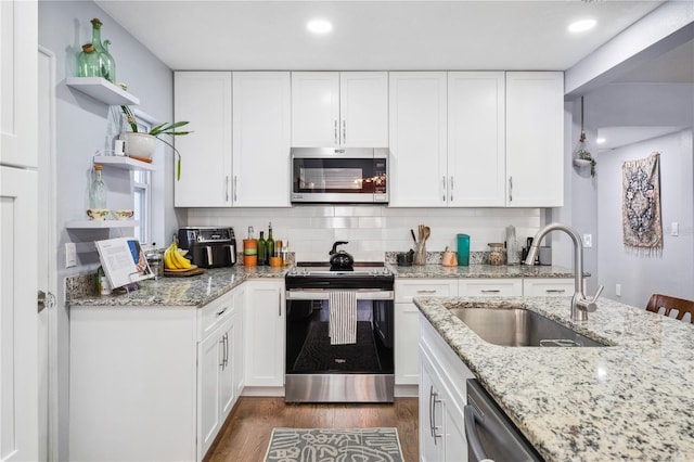 kitchen featuring open shelves, a sink, stainless steel appliances, white cabinetry, and dark wood-type flooring